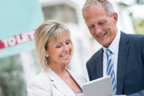 man and woman looking at ipad outside