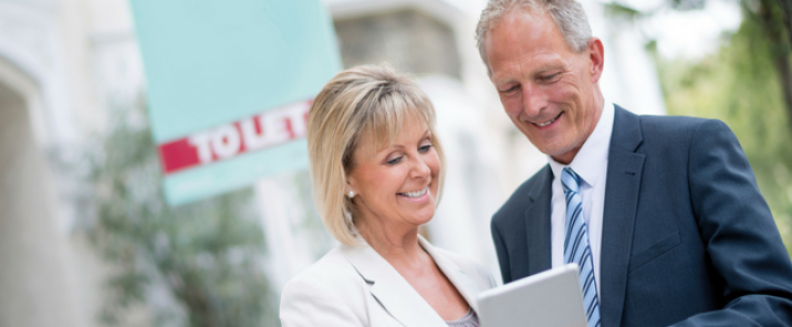 man and woman looking at ipad outside