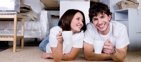 man and woman lying on floor with mugs smiling