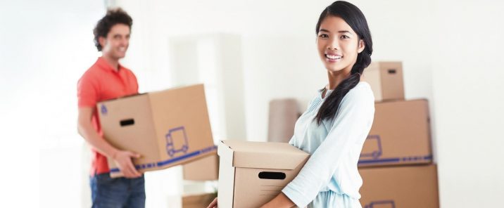 woman and man holding boxes moving house