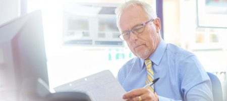 man in office at desk looking at paper