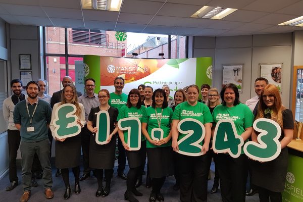 Macmillan staff holding money signs