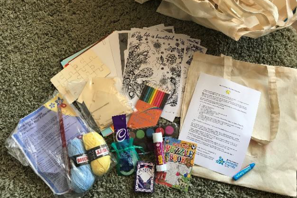 stationery, bags, activities, yarn, cards, and chocolate on floor