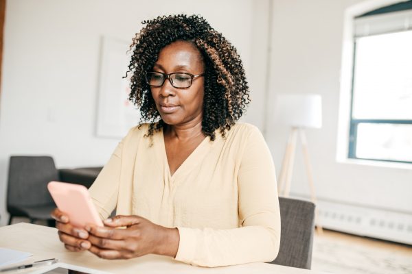 Woman looking at pink phone at desk