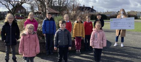 Children standing by tree woman holding mansfield bs cheque